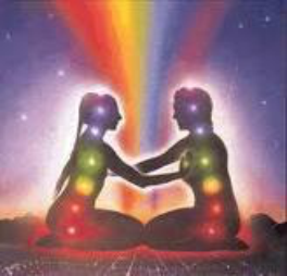 picture of two outline figures male and femalein meditation reaching out to each other and their chakra points iluminated in color.